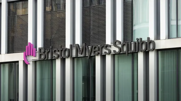 Modern glass window office building facade with the logo of Bristol Myers Squibb. 