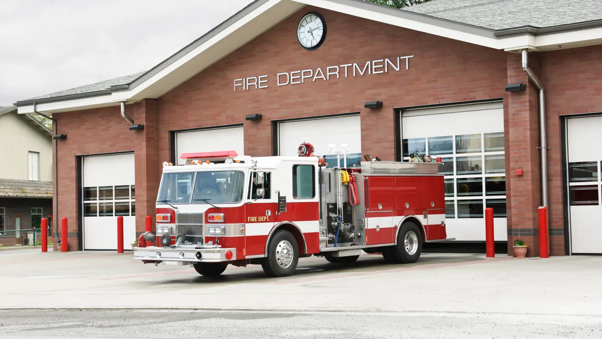 A fire truck parked in front of a fire station.