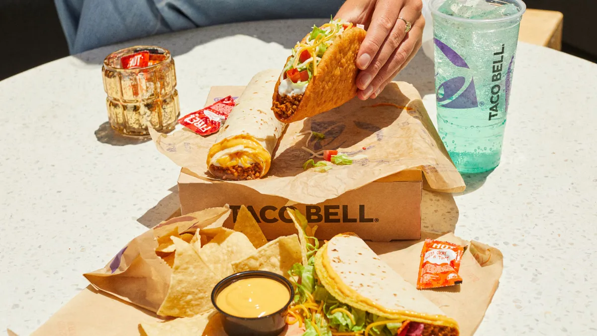 The content of a Taco Bell $7 Luxe Cravings box spread out on a table.