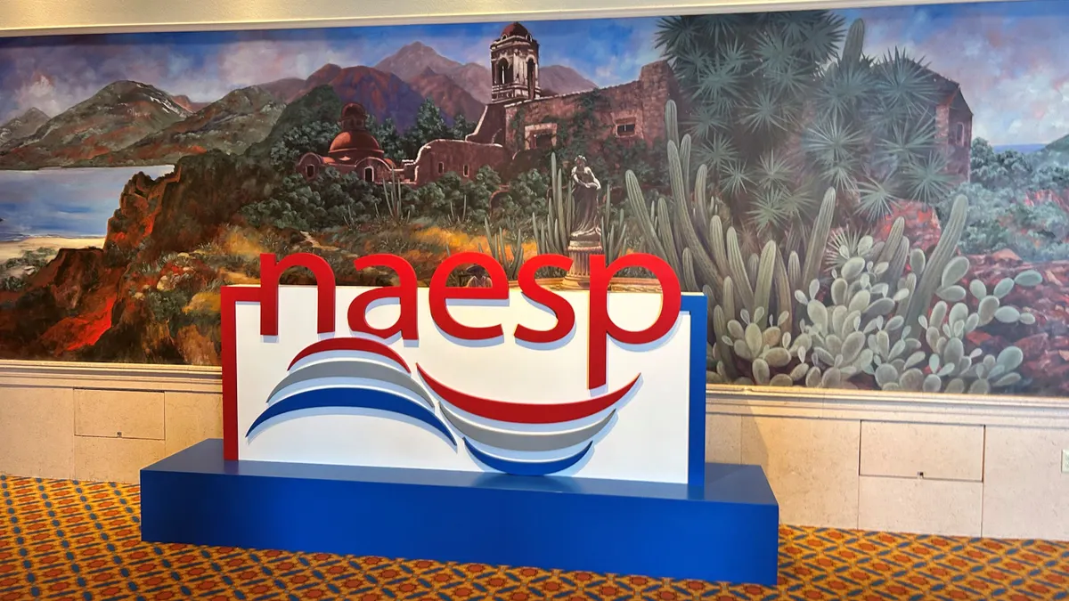 A large sign that says "NAESP" stands in a convention center hallway.