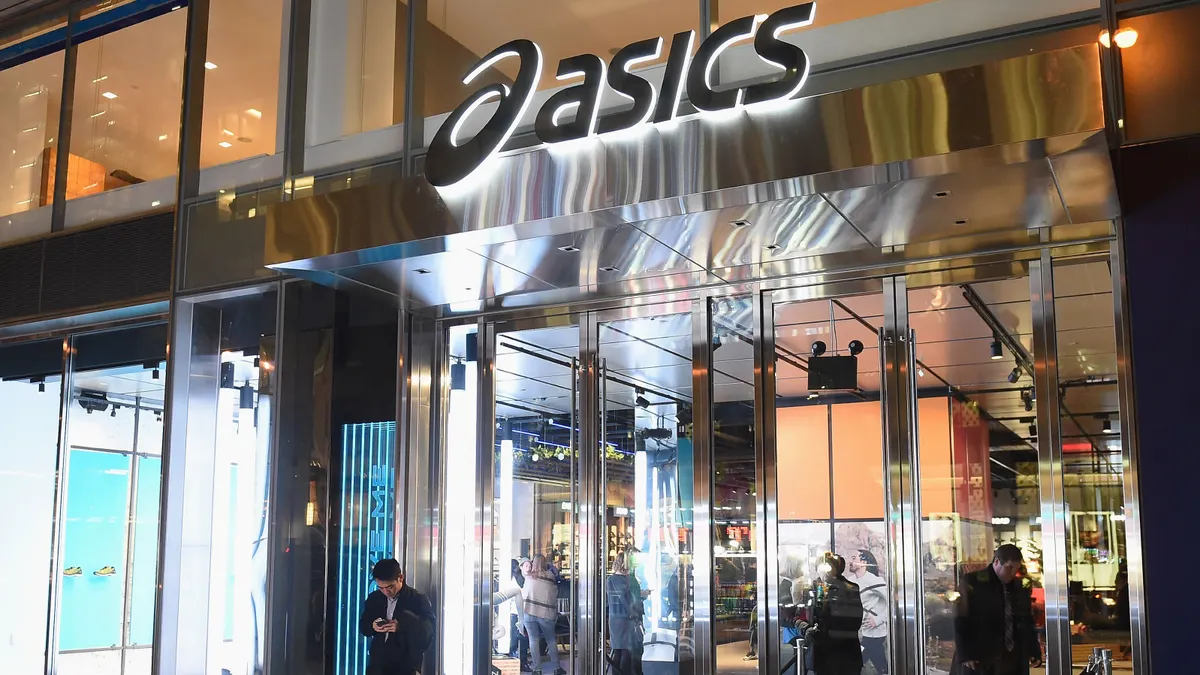 Lighted Asics store exterior, as seen from the outside at night.