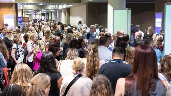 Attendees crowd into the entrance of a room at a conference