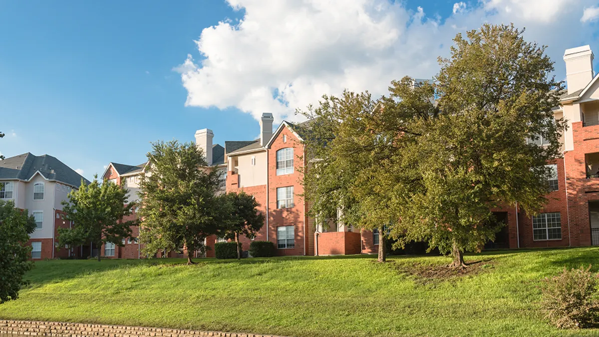 ypical multistory riverside apartment building complex surrounded by mature trees in Irving, Texas, USA.
