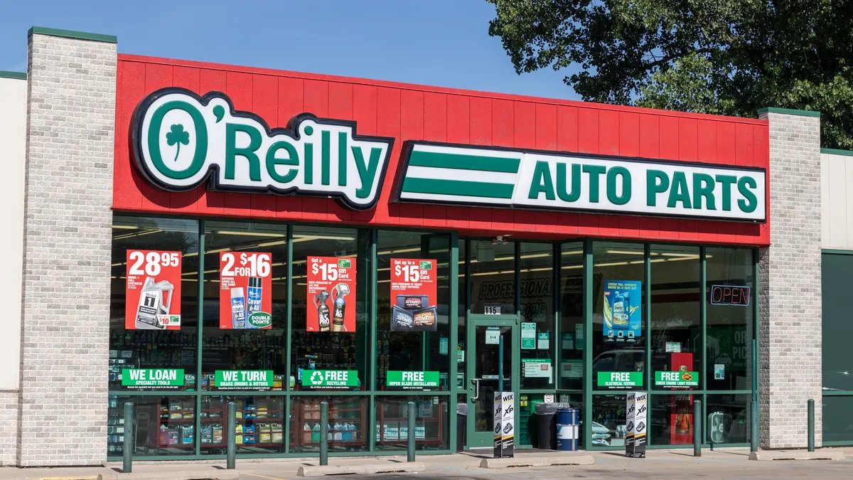 An O'Reilly Auto Parts storefront with product deal posters in the windows.