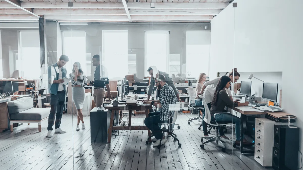 A group of young business people in smart casual wear work together in a creative office.