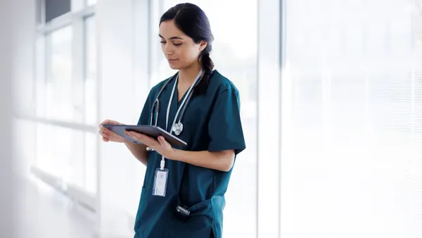 a person in scrubs uses a tablet