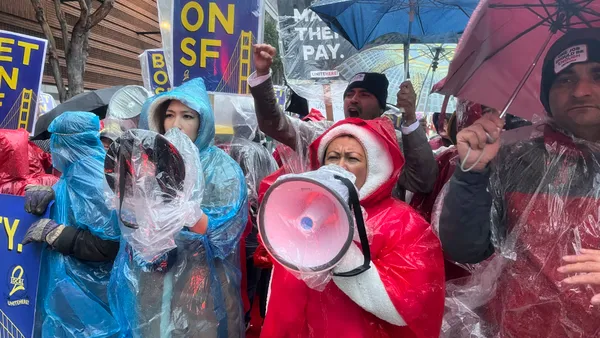 Hotel workers hold megaphones in a protest.