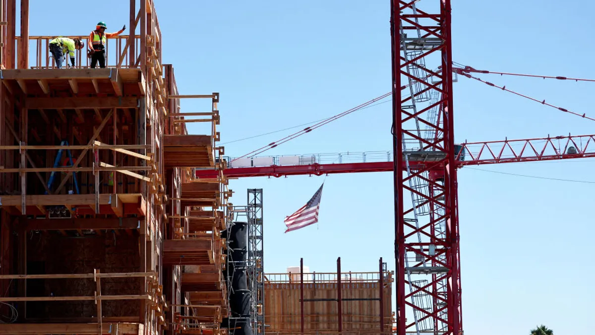 Two construction workers work on a mixed-use complex in Los Angeles.