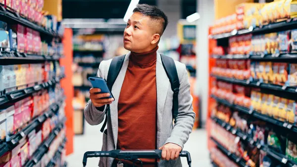 A man checks his phone as he shops