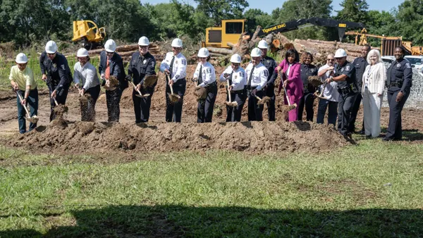 A line of people, including several police officers, with shovels