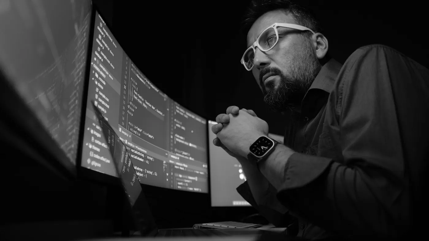 Person working on a computer with multiple screens.