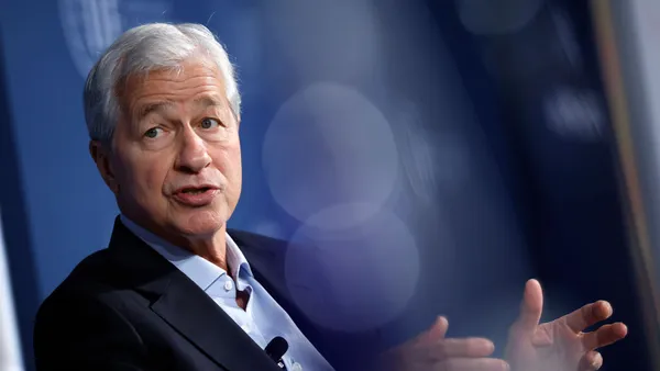 Jamie Dimon, the CEO of JPMorgan Chase bank, talks and holds his hands out in front of him.