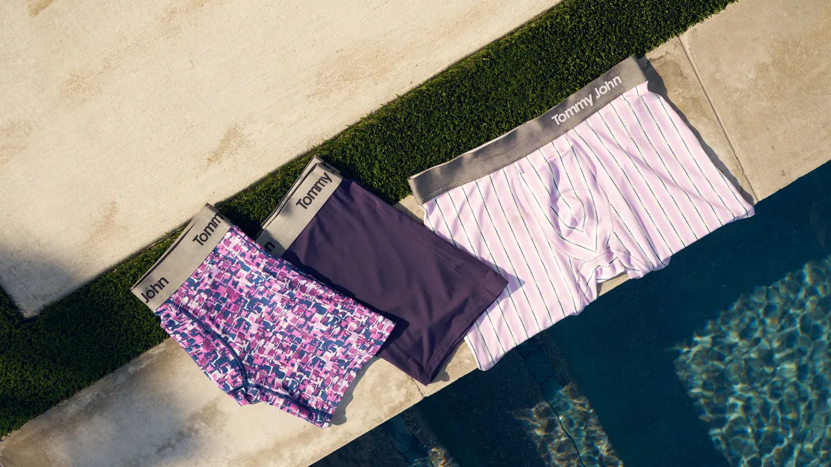 Several colorful pairs of underwear next to a pool