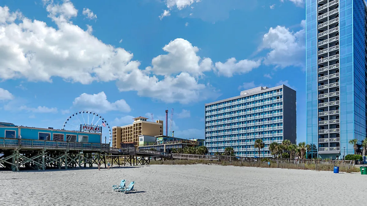 Two beach chairs on Myrtle Beach in front of a glossy high rise.