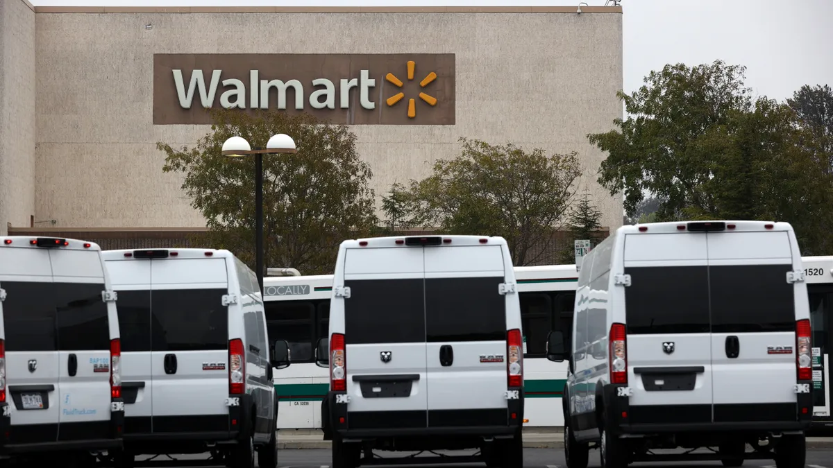 delivery vans parked outside of a walmart store with a sign on the wall.