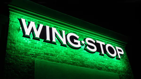 A close up of a white logo that says Wing Stop with a neon green glow.