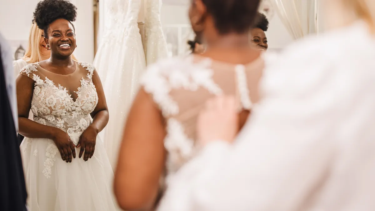 A bride tries on a dress at a store.