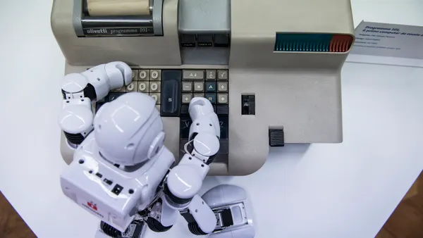 A small robot uses an antique Olivetti Programma 101 computer.
