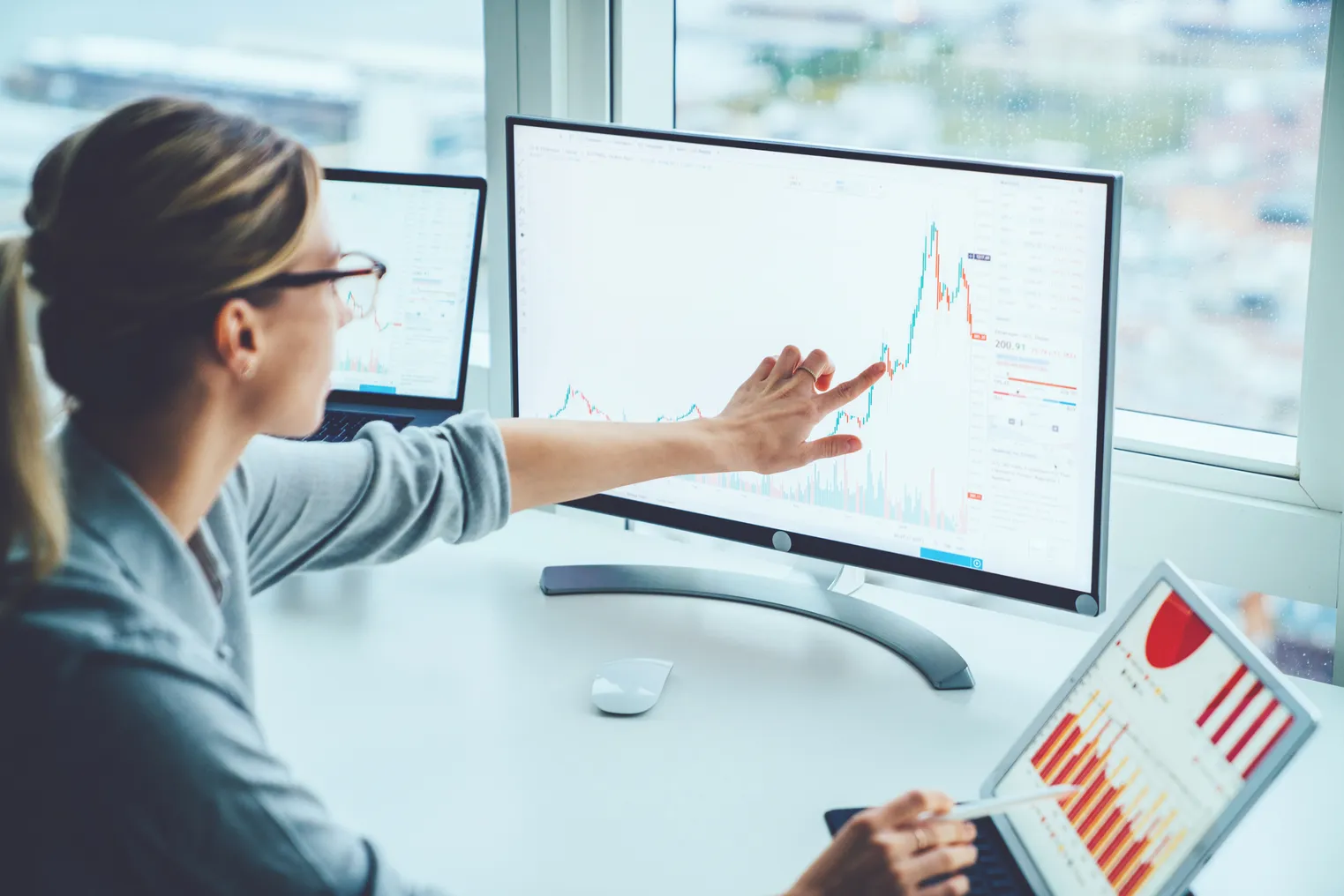 Business woman studying financial data on computer screen.