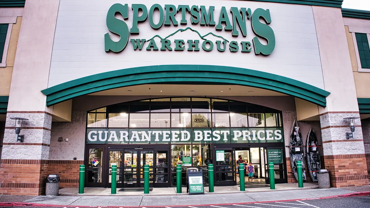 A storefront with a sign "Sportsman's Warehouse" in green trim with windows.