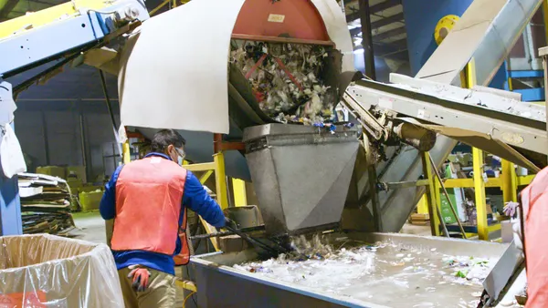 A worker separates out recycling at a machine