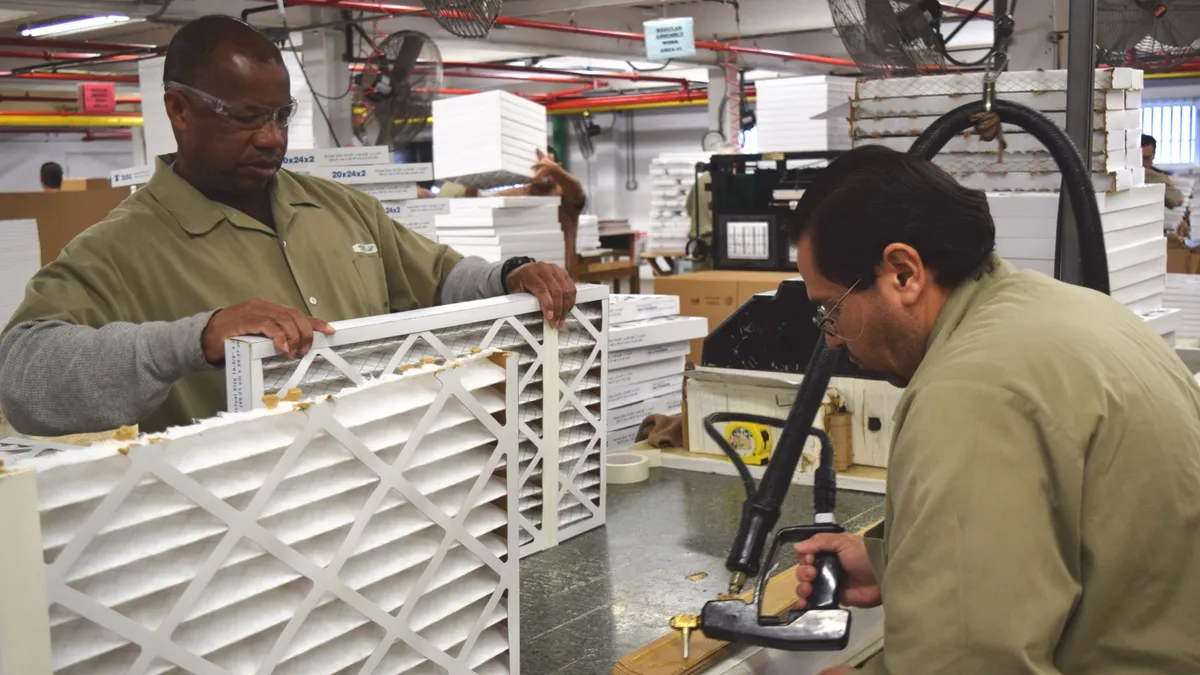 Two men engaged in manufacturing a task