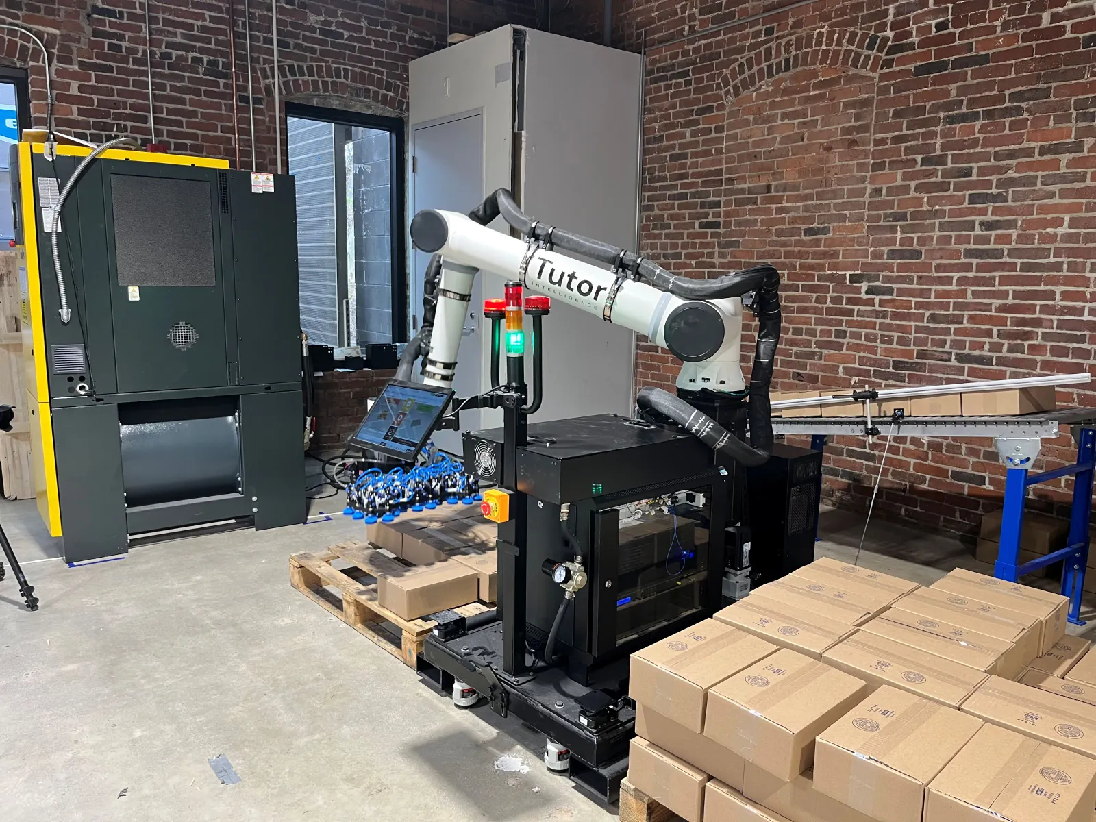 Tutor Intelligence's Cassie robot autonomously picks up and stacks the boxes on a pallet as part of a demonstration.