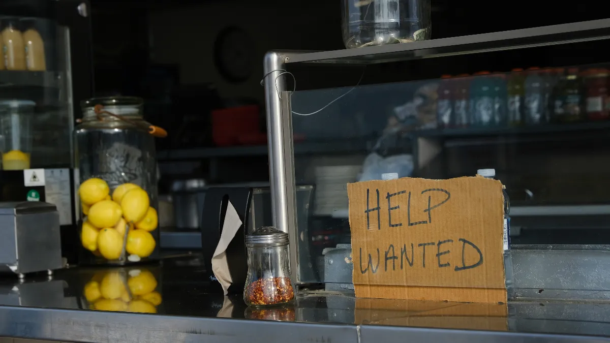 Help wanted sign on a restaurant counter