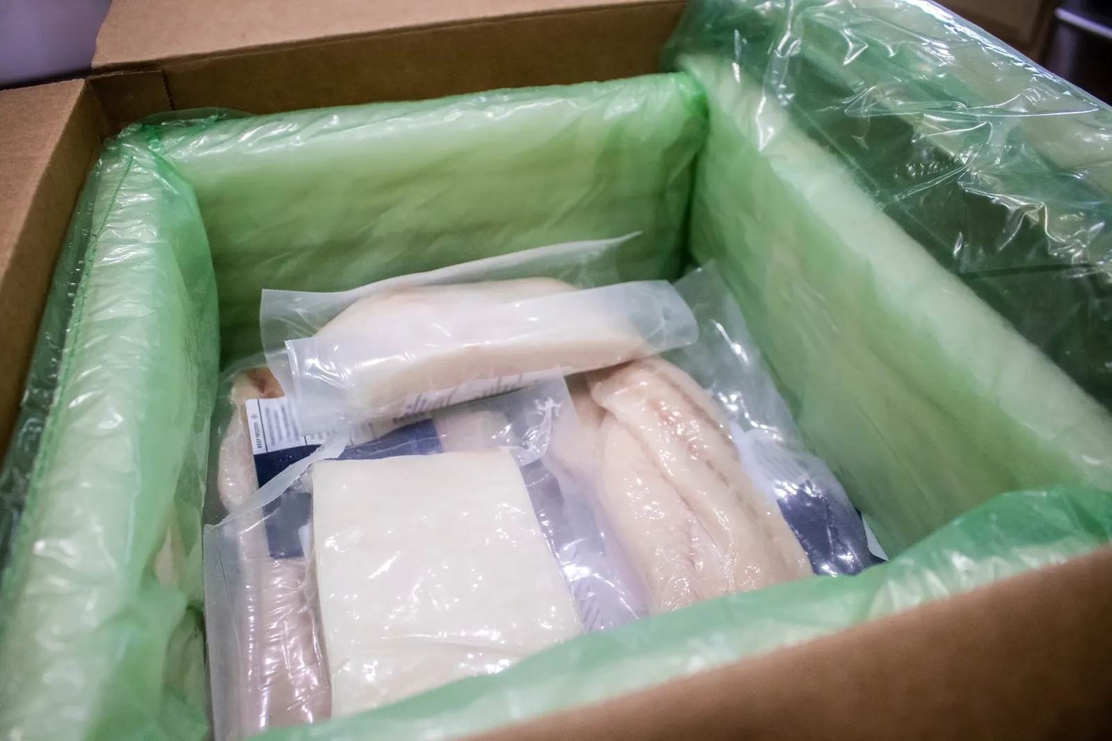 A box filled with dry ice and frozen fish.
