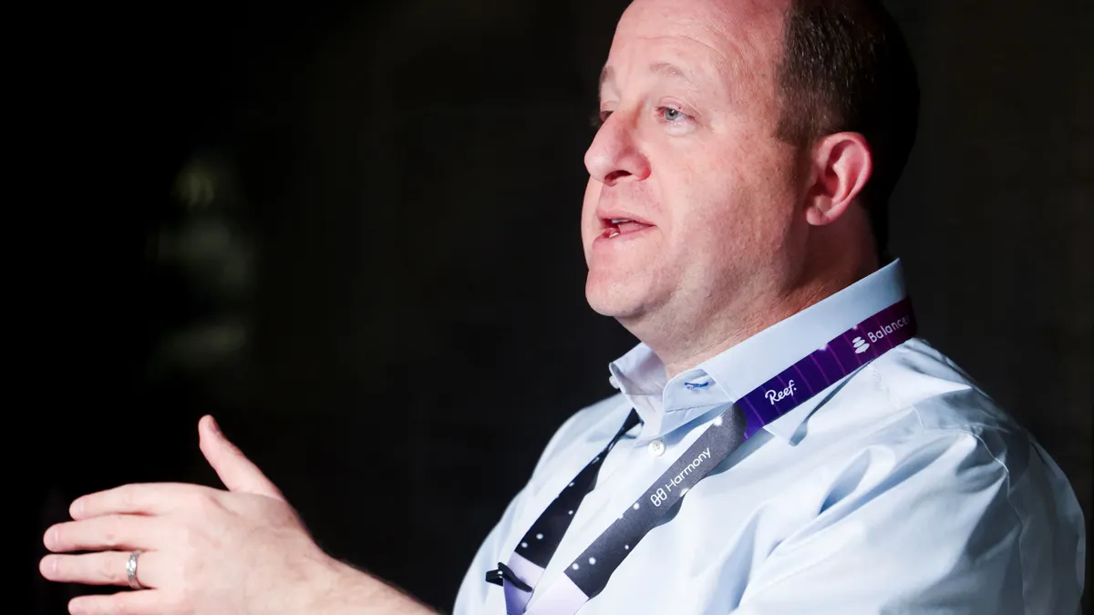 Colorado governor Jared Polis talks on a podcast.
