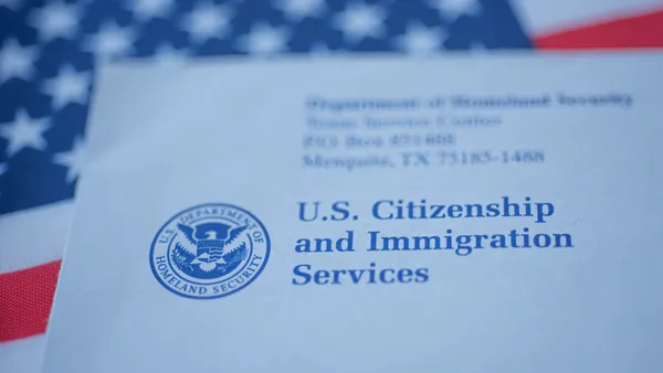 Letter (Envelope) from USCIS on flag of USA background. Close up view.