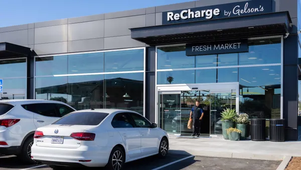 A photo of the exterior of a store. A sign over the door says "ReCharge by Gelsons" and a person is walking out of the door.