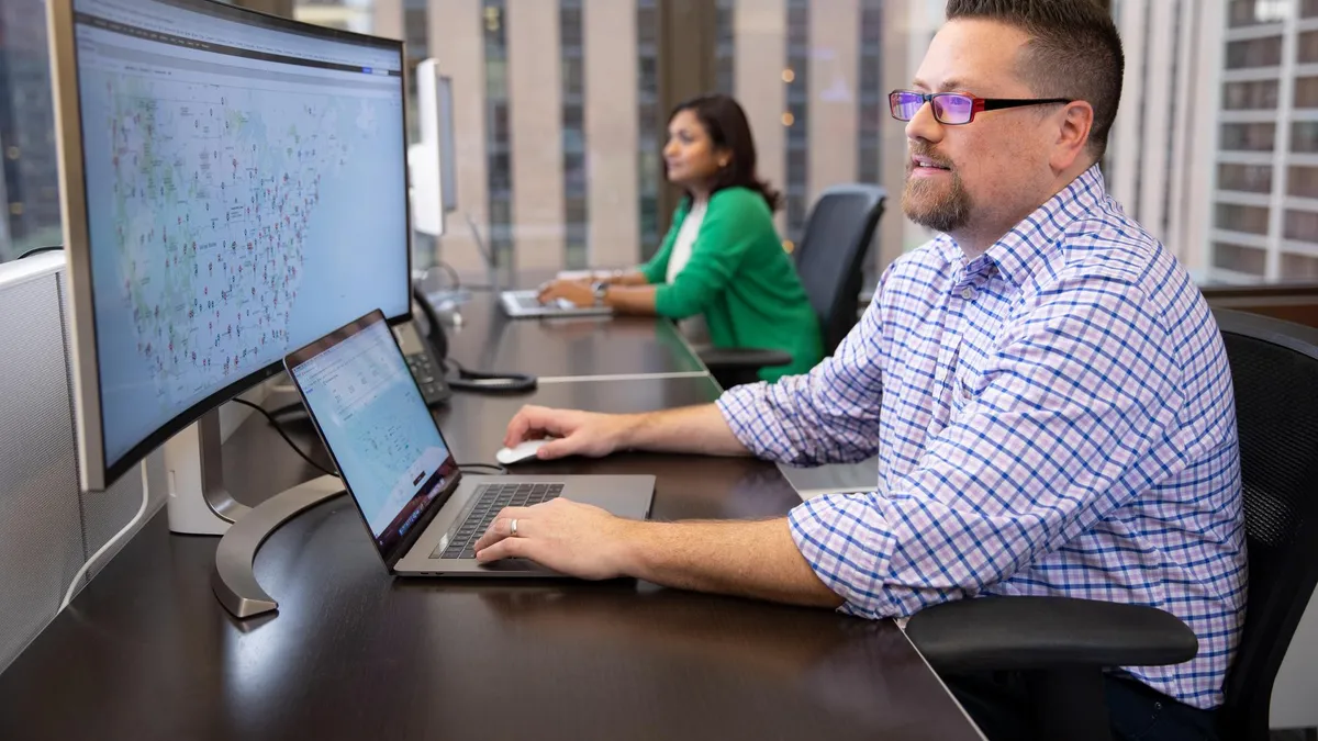 An XPO software engineer looks at a network map in an office.