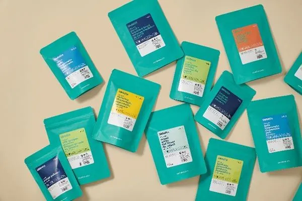 A variety of turquoise pouches with white labels that have DavidsTea branding and product descriptions.