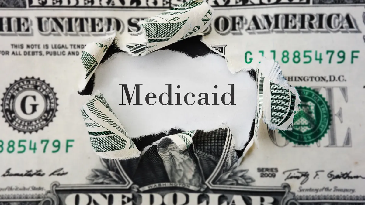 Text of the word 'Medicaid' in the middle of a U.S. dollar bill