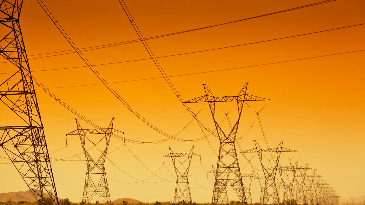 Electrical power grid and power line towers at sunset.