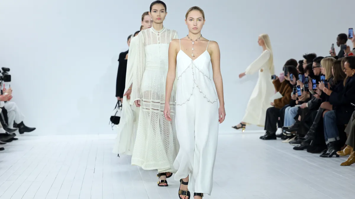 Models wearing pale colors walk the Chloé Womenswear runway against a white backdrop.