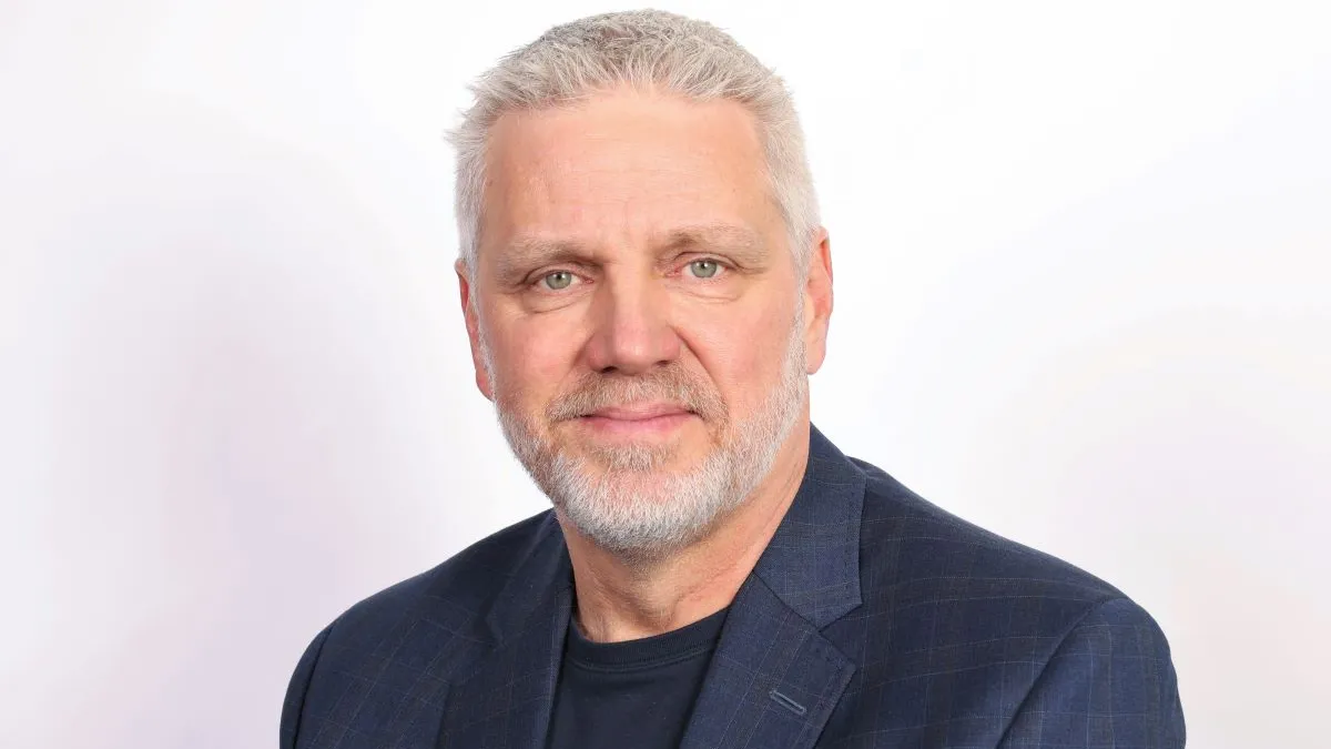 An image of a man with white hair wearing a suit