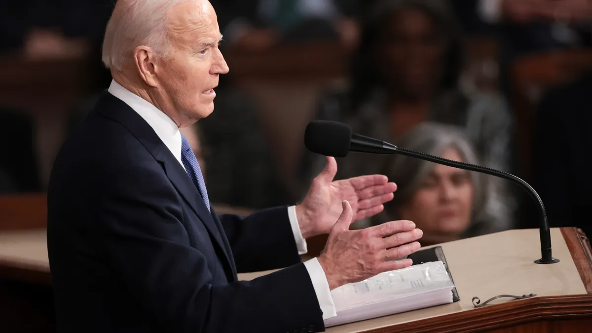 President Joe Biden stands at a podium and addresses members of Congress during his State of the Union speech on March 7