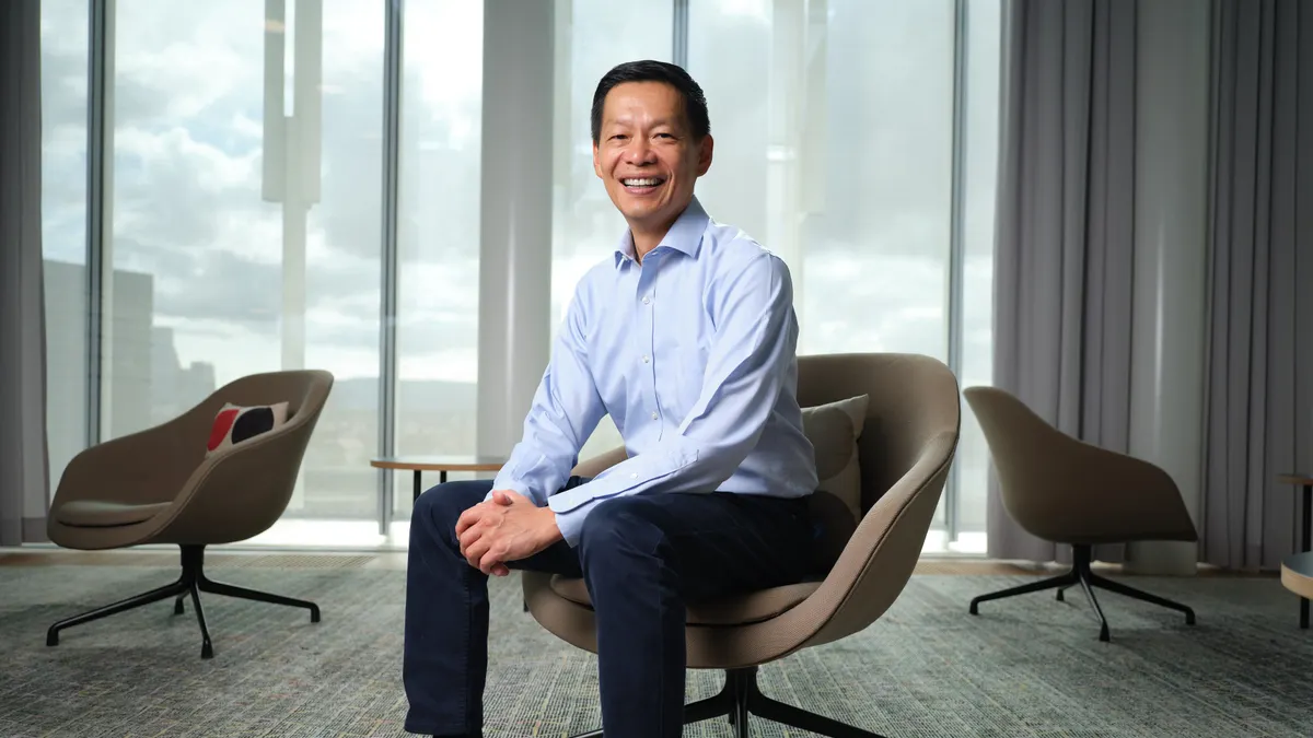 A man in business attire stands for a photo.