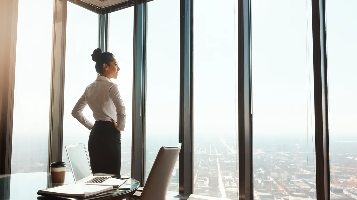 business person standing with her hands on her hips in the office