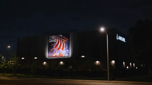 A building appearing dark at night, with street lights facing outward and surrounding it.