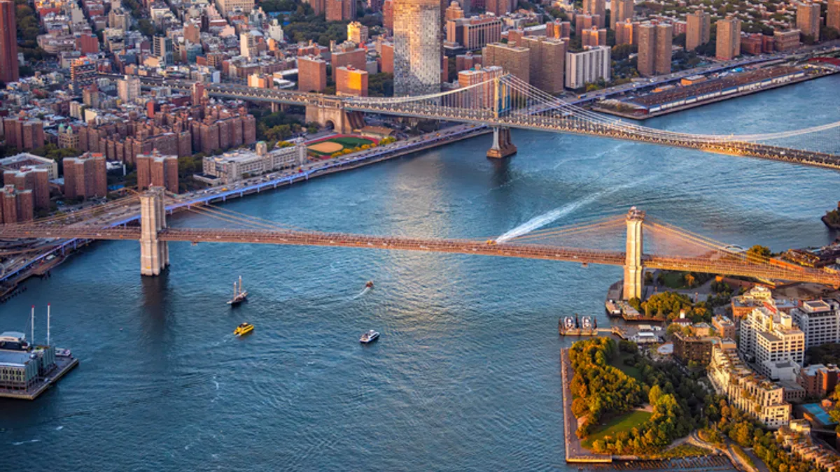 an aerial view of the Brooklyn and Manhattan Bridges spanning the East River between Brooklyn and Lower Manhattan in New York City.