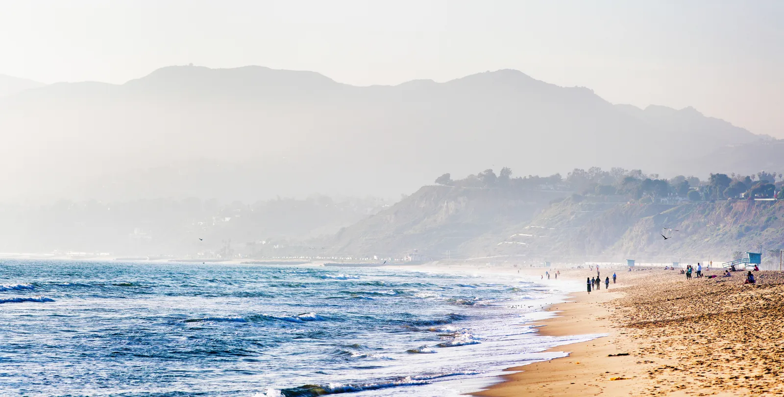 The beachfront in Santa Monica with people strolling along it.