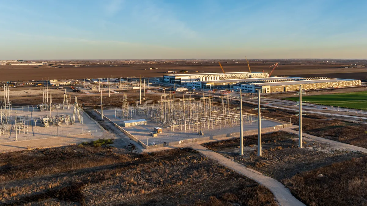 An electric substation next to an industrial building.