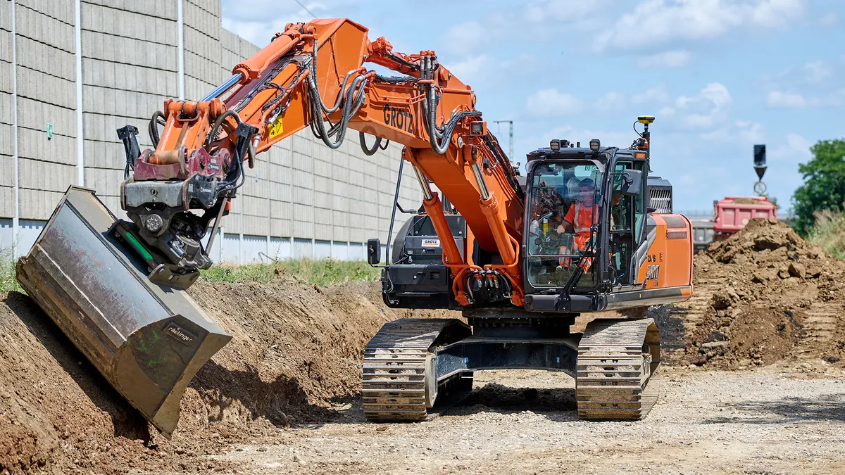 A bulldozer works on a dusty jobsite