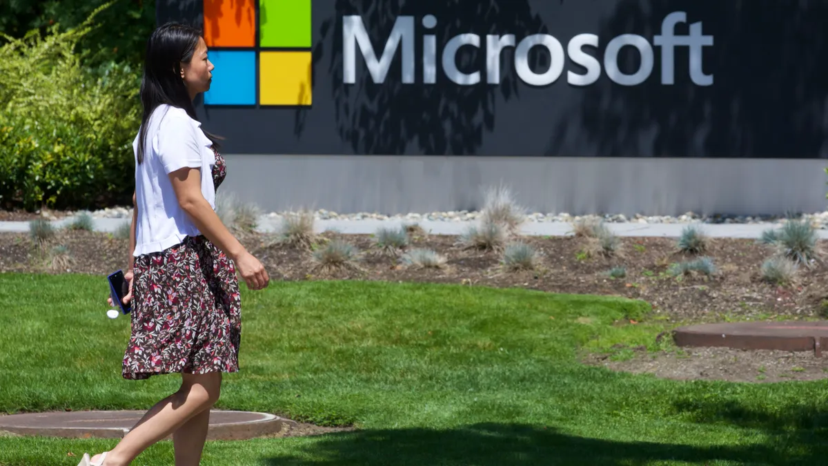 A pedestrian walks by a sign on Microsoft Headquarters campus in Redmond, Washington.