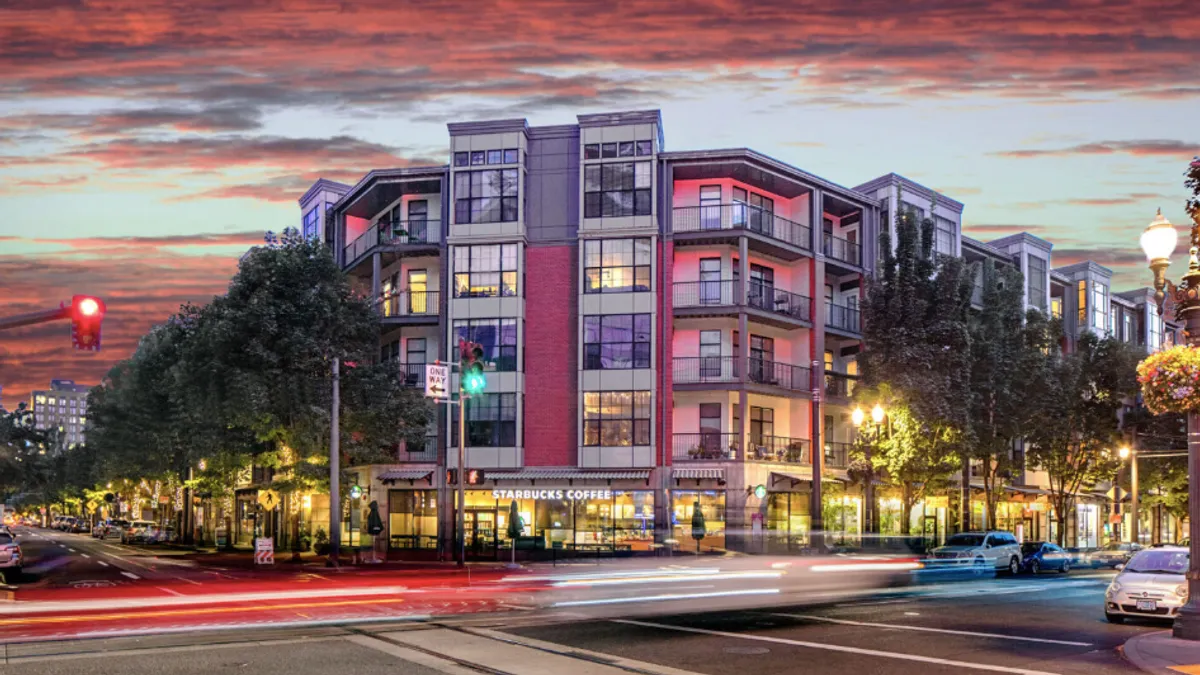 Four story, new, modern apartment with a Starbucks on the ground floor.