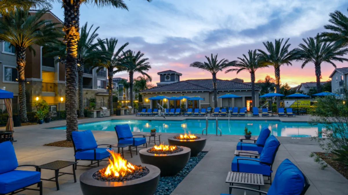 Pool surrounded by apartment building and palm trees