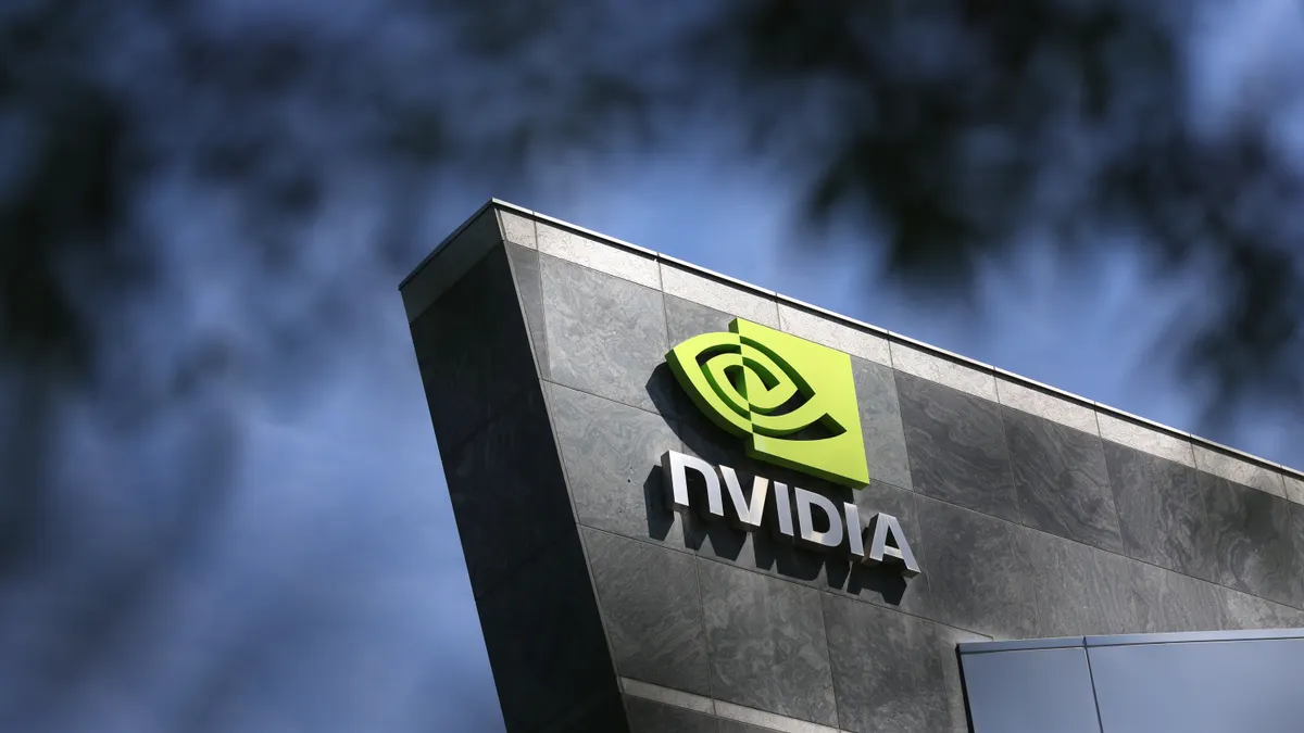 A sign bearing Nvidia's corporate logo is seen on a building viewed through trees.